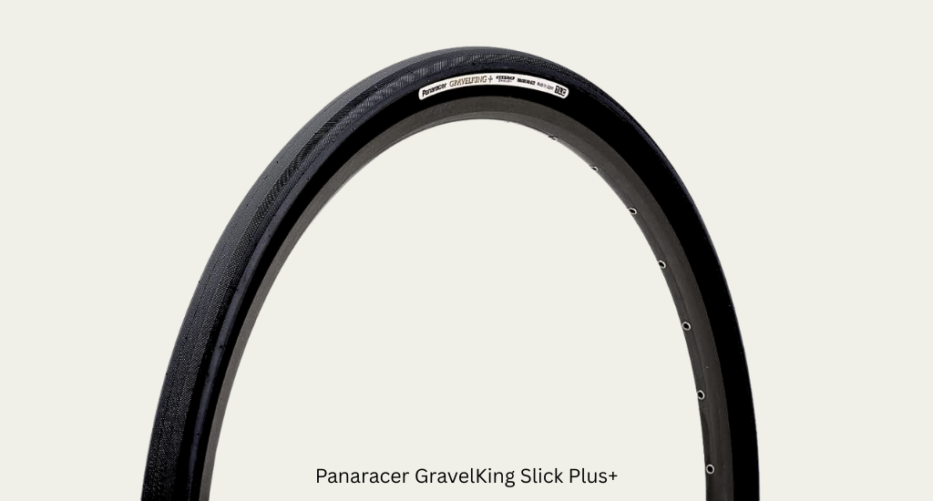 A close-up of a Panaracer GravelKing Slick Plus+ bicycle tire mounted on a rim. The tire features a smooth, black tread designed for speed on pavement and gravel.